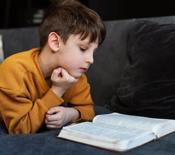 Niña leyendo la Biblia en la mesa